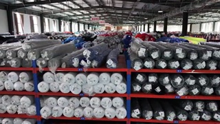 Fabric and material sourcing — textile warehouse with colorful fabric rolls